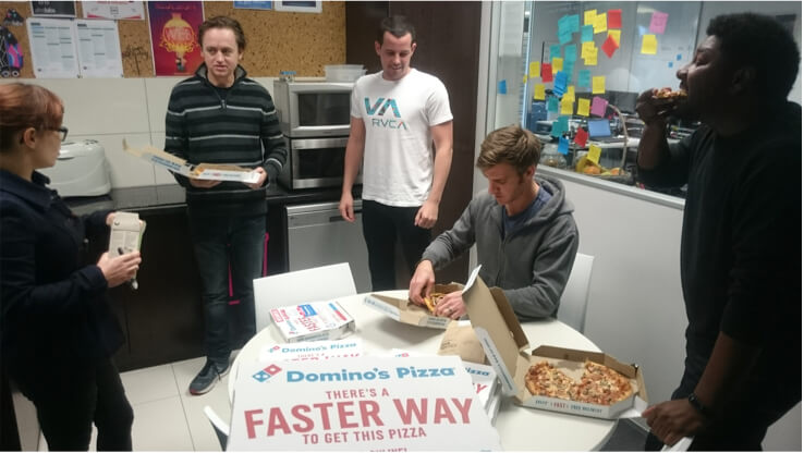 The Afrolabs team celebrating with Brad over pizza
